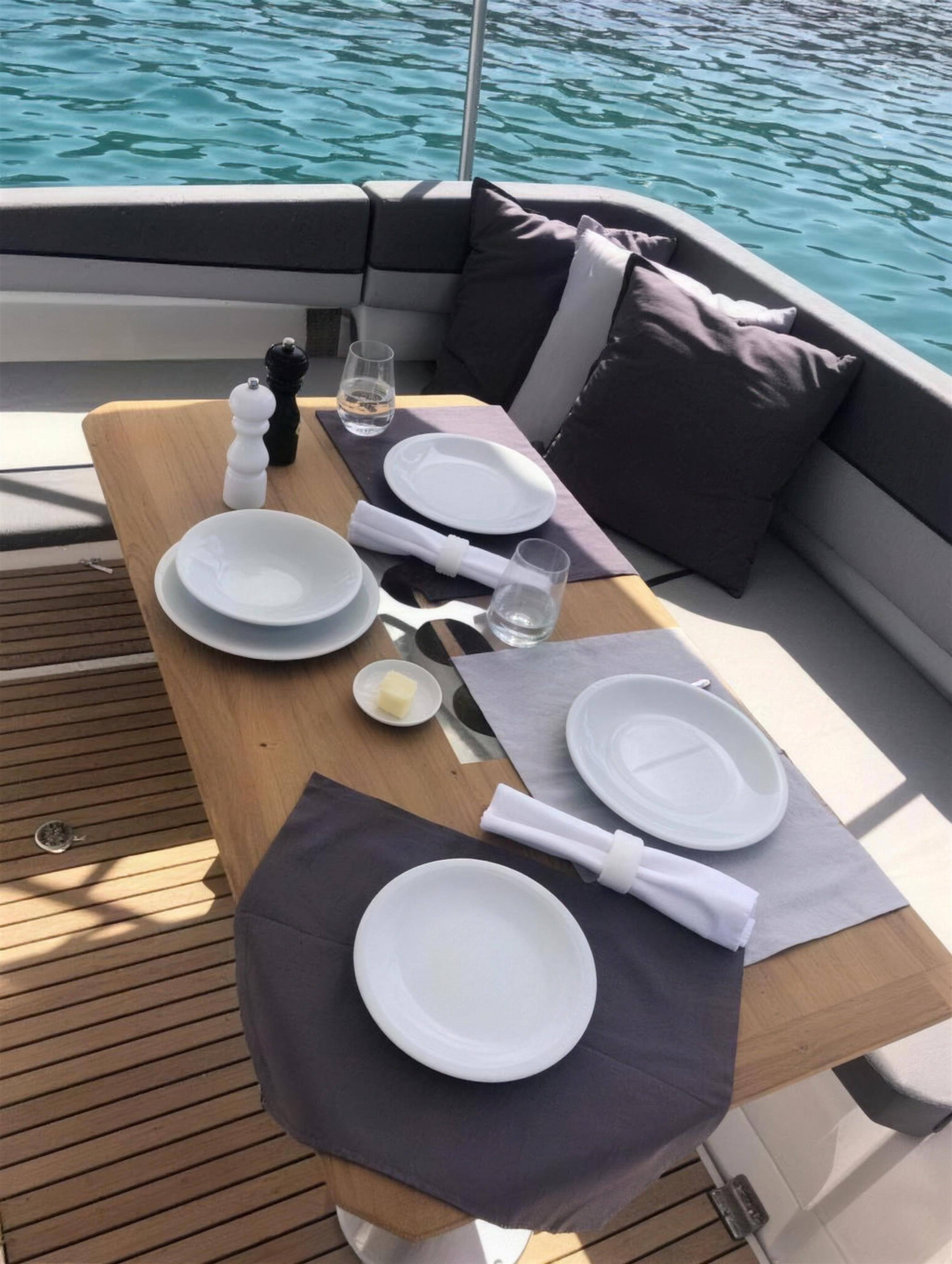 The teak cockpit table laid for lunch under the shade of the bimini